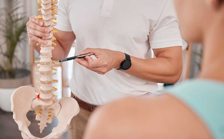 A chiropractor checks the posture of an adult patient during a wellness session in a comfortable clinic setting.